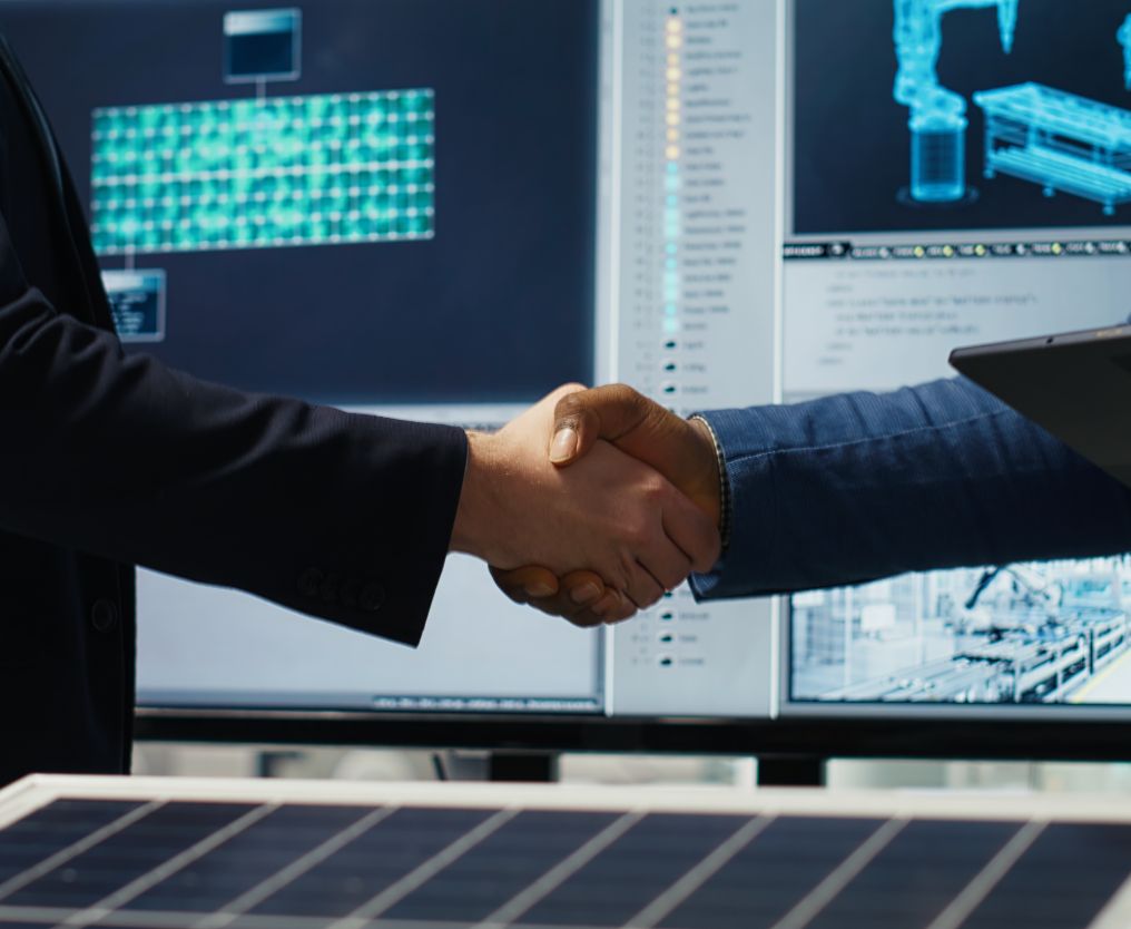 Two people shaking hands in a business setting.