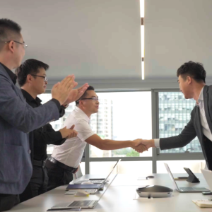 Business professionals shaking hands in office setting.