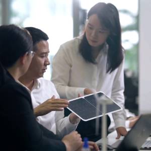 Team collaborating over a tablet in an office.